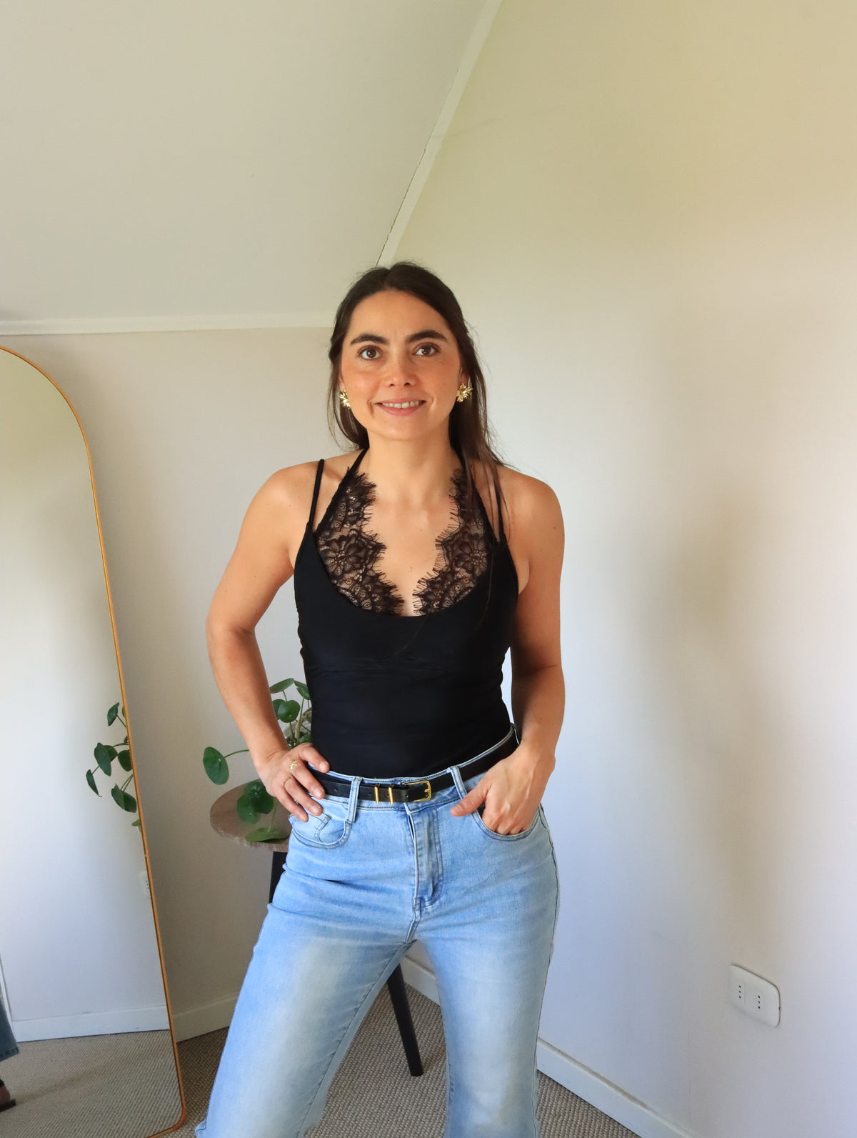 Body Mora negro con escote en V de encaje, vista frontal con jeans