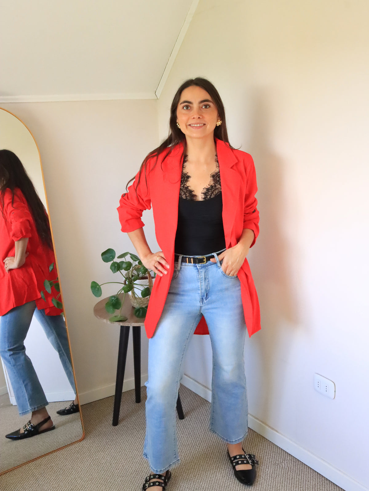 Body Mora negro bajo blazer rojo abierto, con jeans