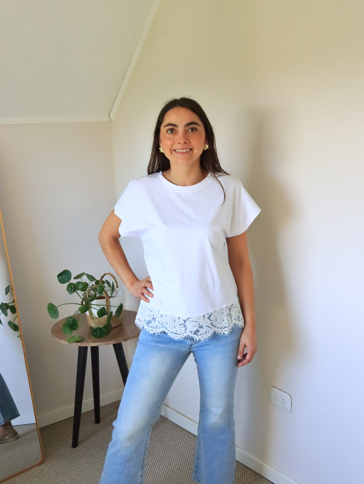 Polera Emma blanca con encaje blanco en el ruedo, de cuerpo entero con jeans