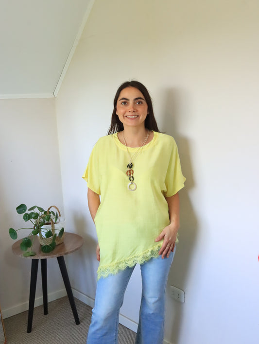 Polera Jana amarilla con ruedo asimétrico de encaje, vista frontal con jeans