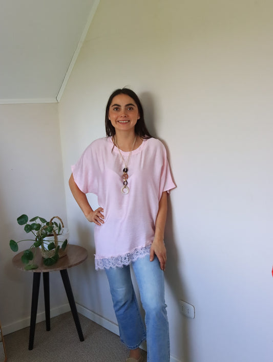 Polera Jana rosa con ruedo asimétrico de encaje, vista frontal con jeans