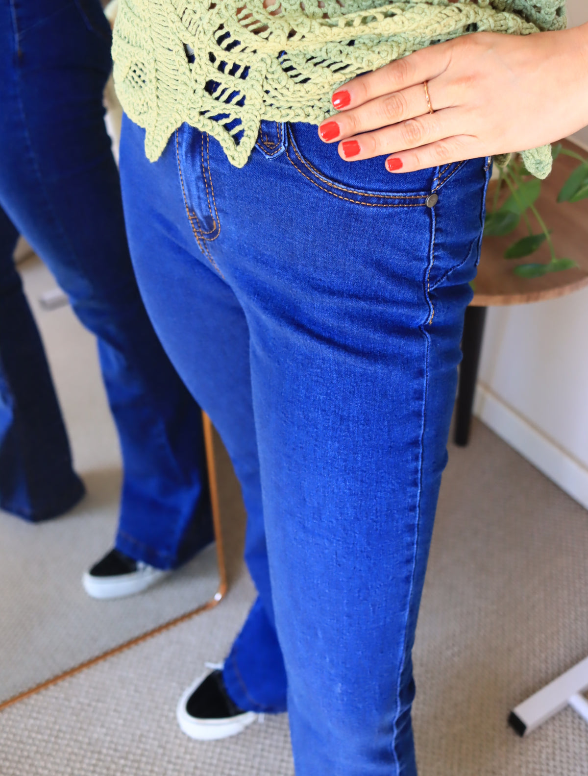 Detalle de la cintura del jeans flare de tiro alto con tejido verde