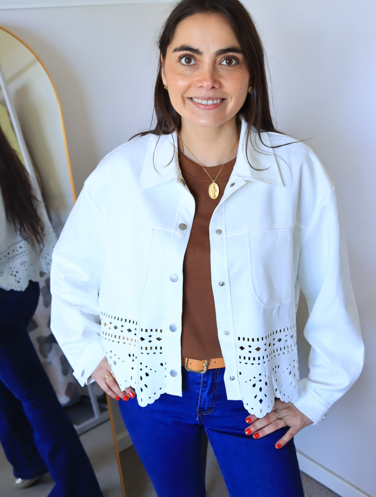 Chaqueta Emilia blanca con calado en el ruedo, sobre polera café y jeans