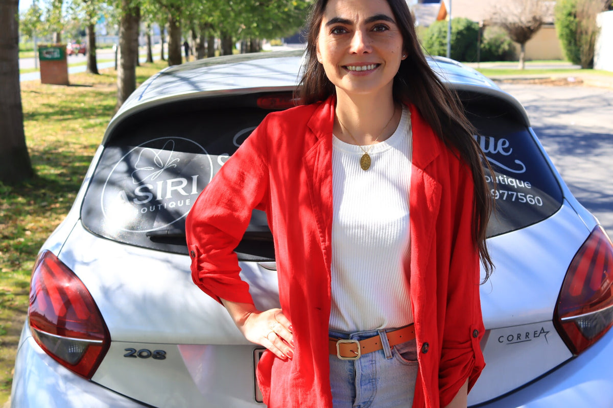 Valeria con blazer rojo junto al ASIRI Móvil, el auto de las entregas presenciales