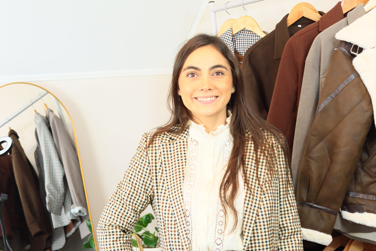Valeria en el showroom de ASIRI con blazer cuadrillé, frente al perchero