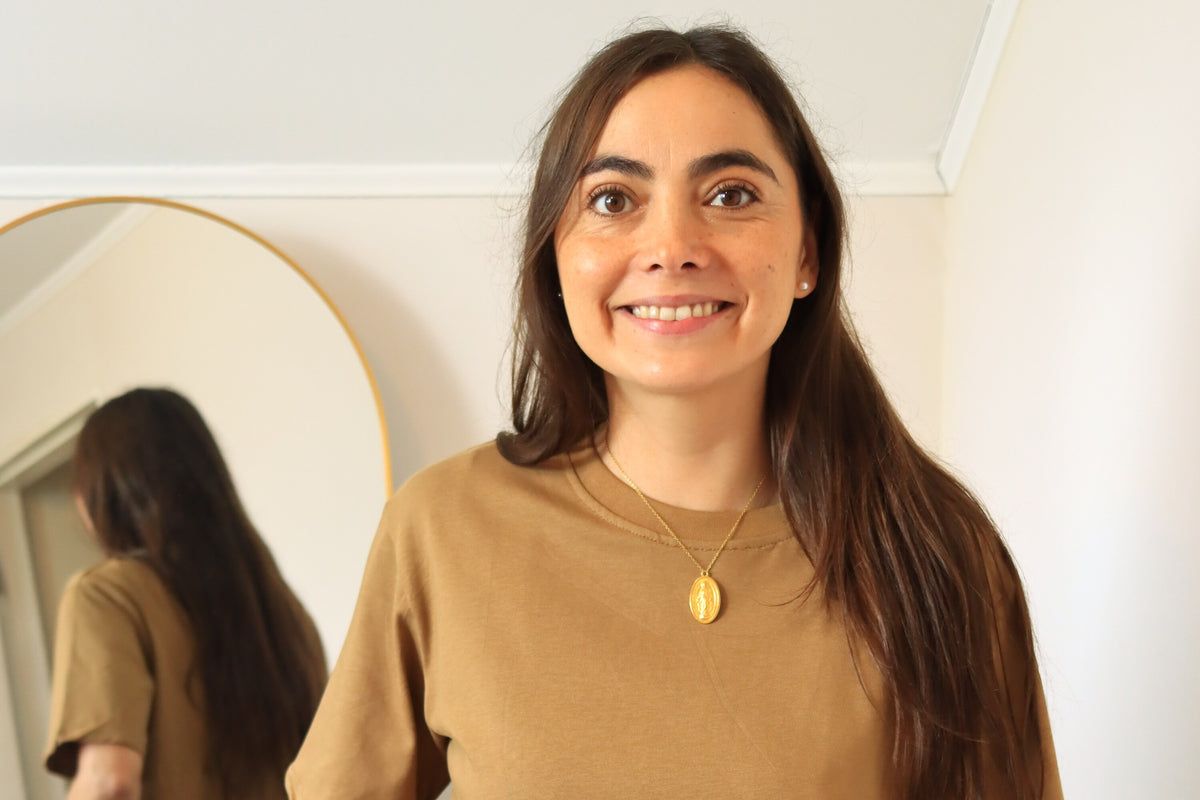 Valeria, fundadora de ASIRI, sonriendo frente al espejo con polera café